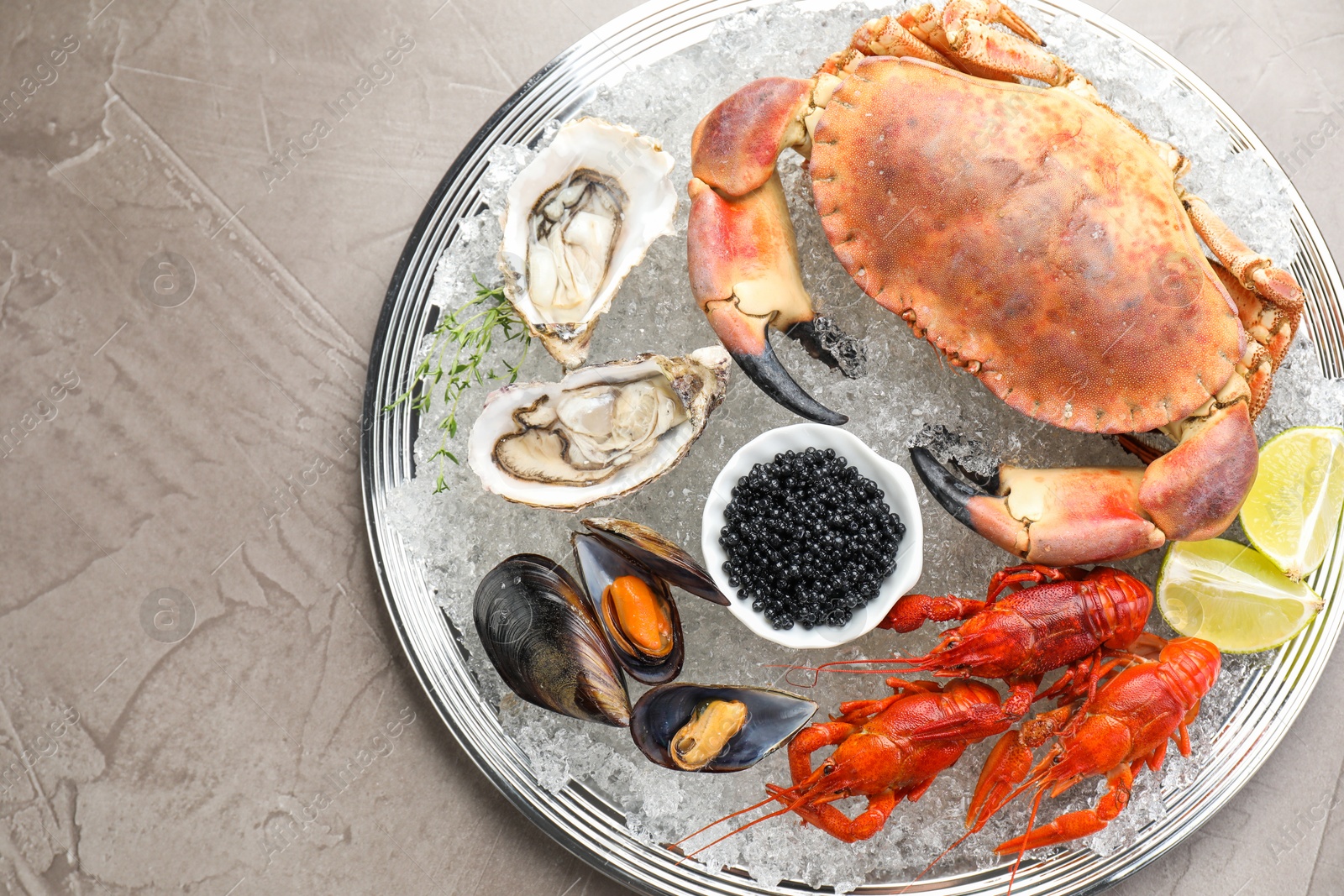 Photo of Many different sea food on grey table, top view