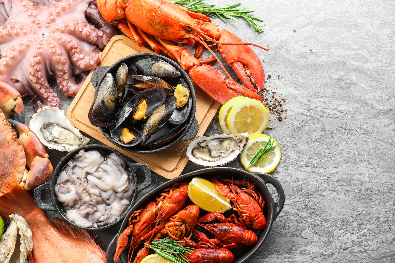 Photo of Many different sea food on grey table, top view