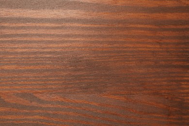 Photo of Applying walnut wood stain. Texture of wooden surface as background, top view