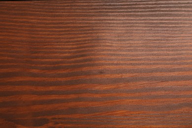 Photo of Applying walnut wood stain. Texture of wooden surface as background, top view