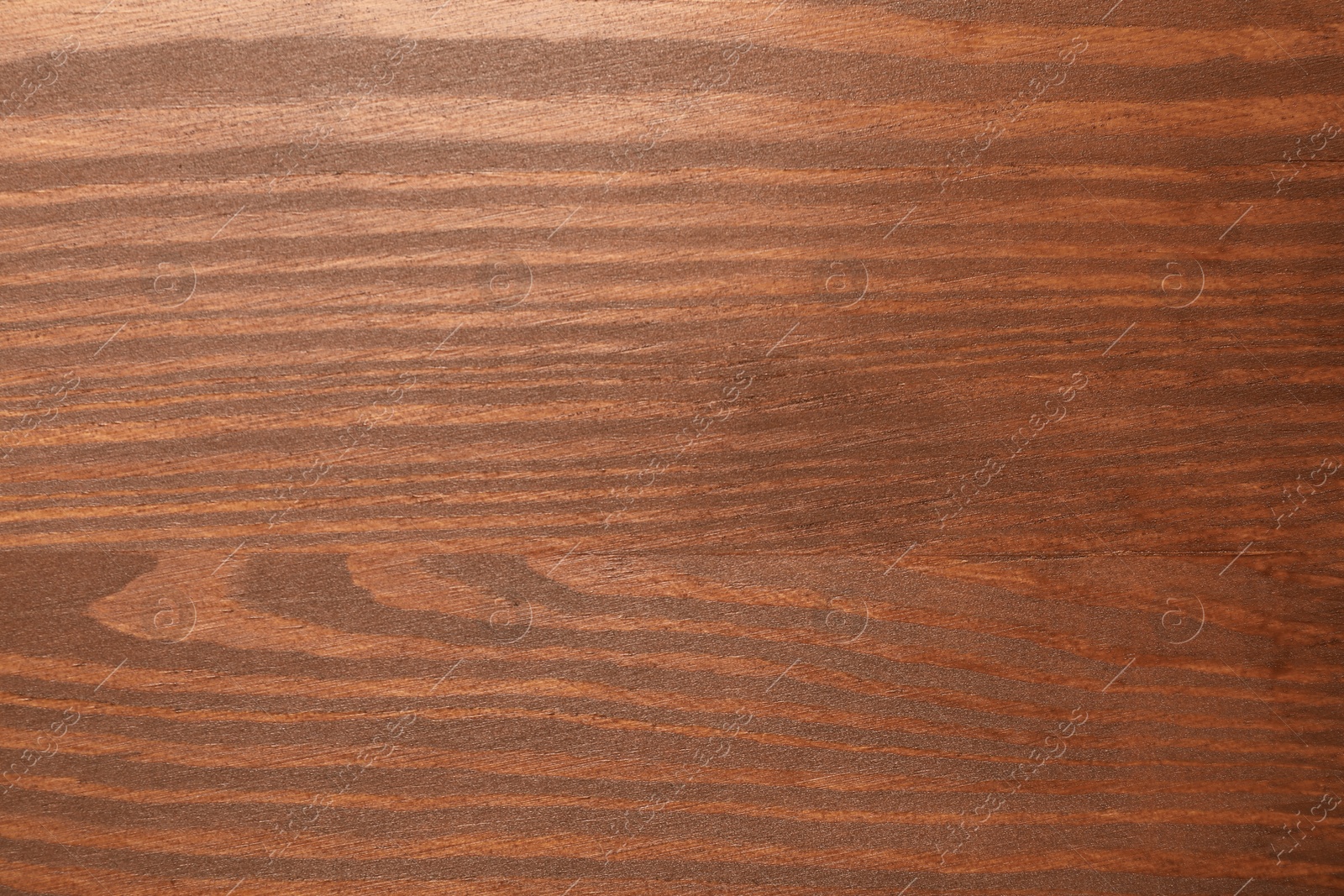 Photo of Applying walnut wood stain. Texture of wooden surface as background, top view