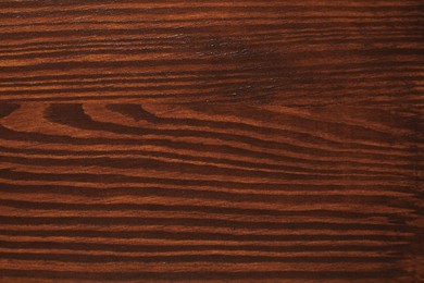 Photo of Texture of wooden surface after applying walnut wood stain as background, top view