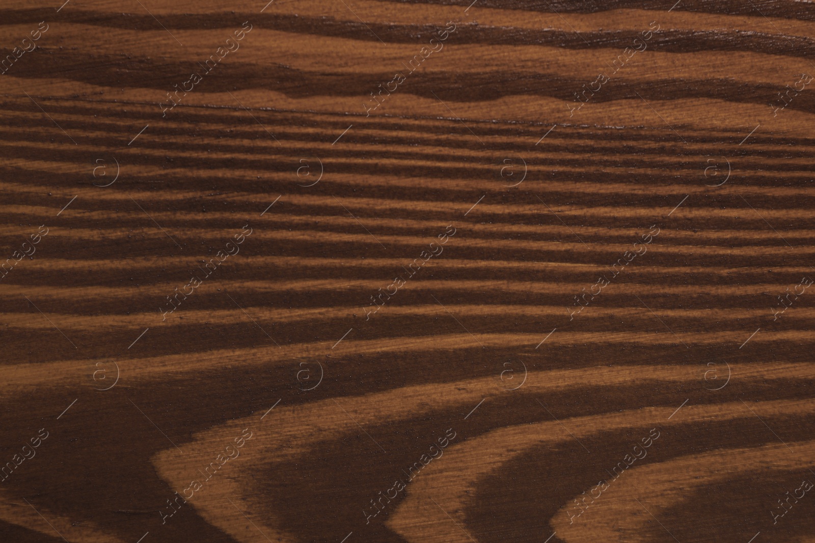 Photo of Texture of wooden surface after applying walnut wood stain as background, closeup