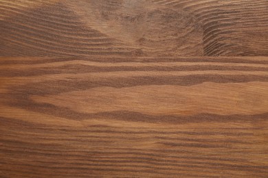 Photo of Applying walnut wood stain. Texture of wooden surface as background, top view