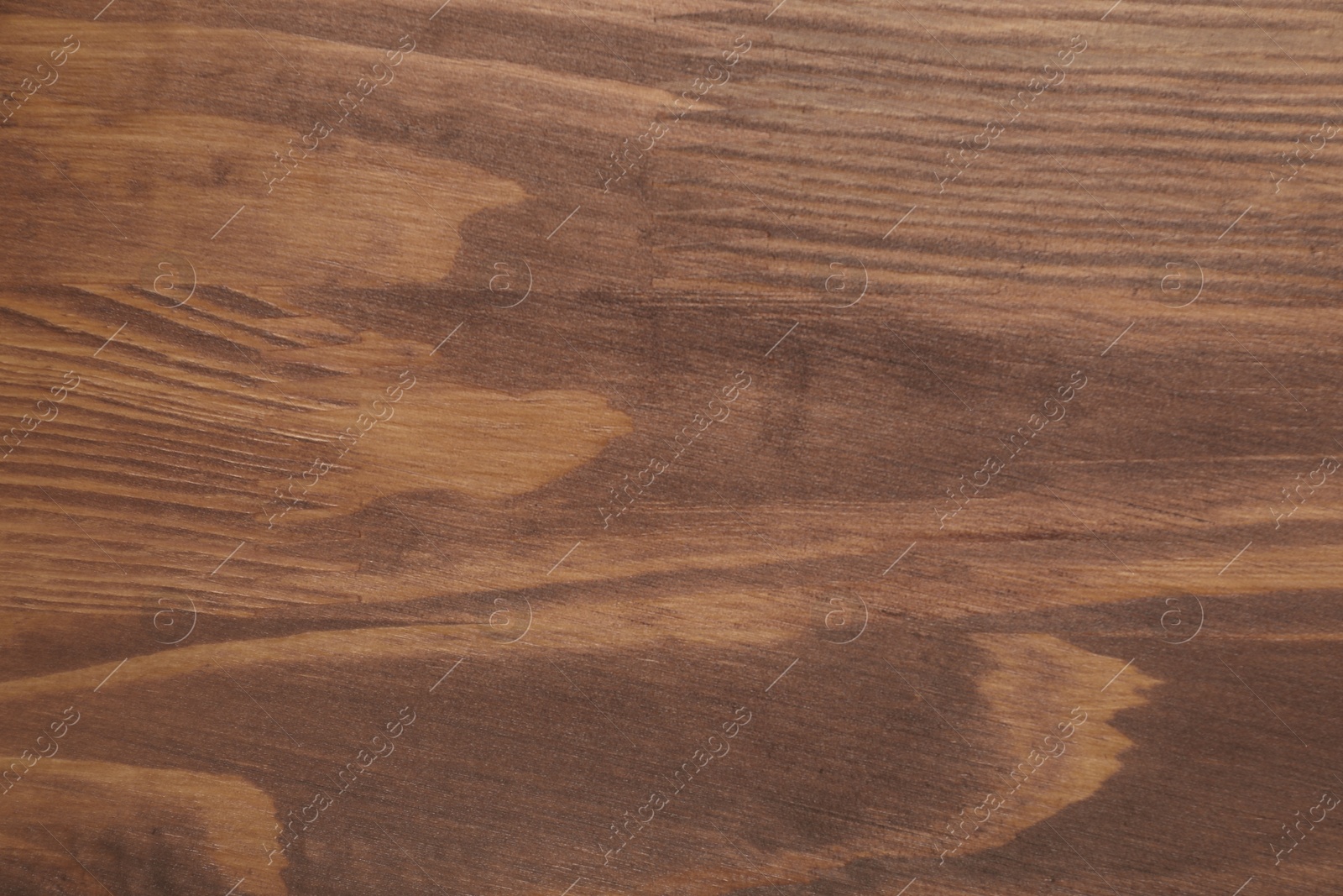 Photo of Applying walnut wood stain. Texture of wooden surface as background, top view