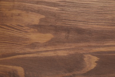 Photo of Applying walnut wood stain. Texture of wooden surface as background, top view