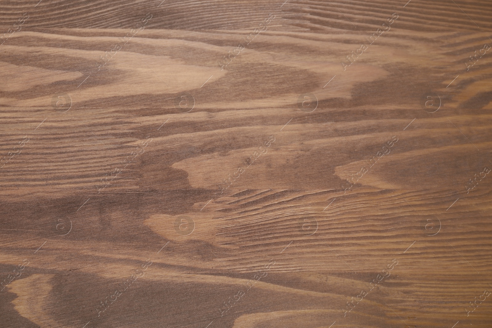 Photo of Applying walnut wood stain. Texture of wooden surface as background, top view