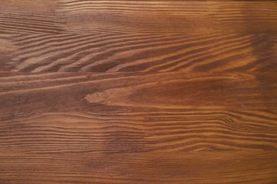 Photo of Applying walnut wood stain. Texture of wooden surface as background, top view