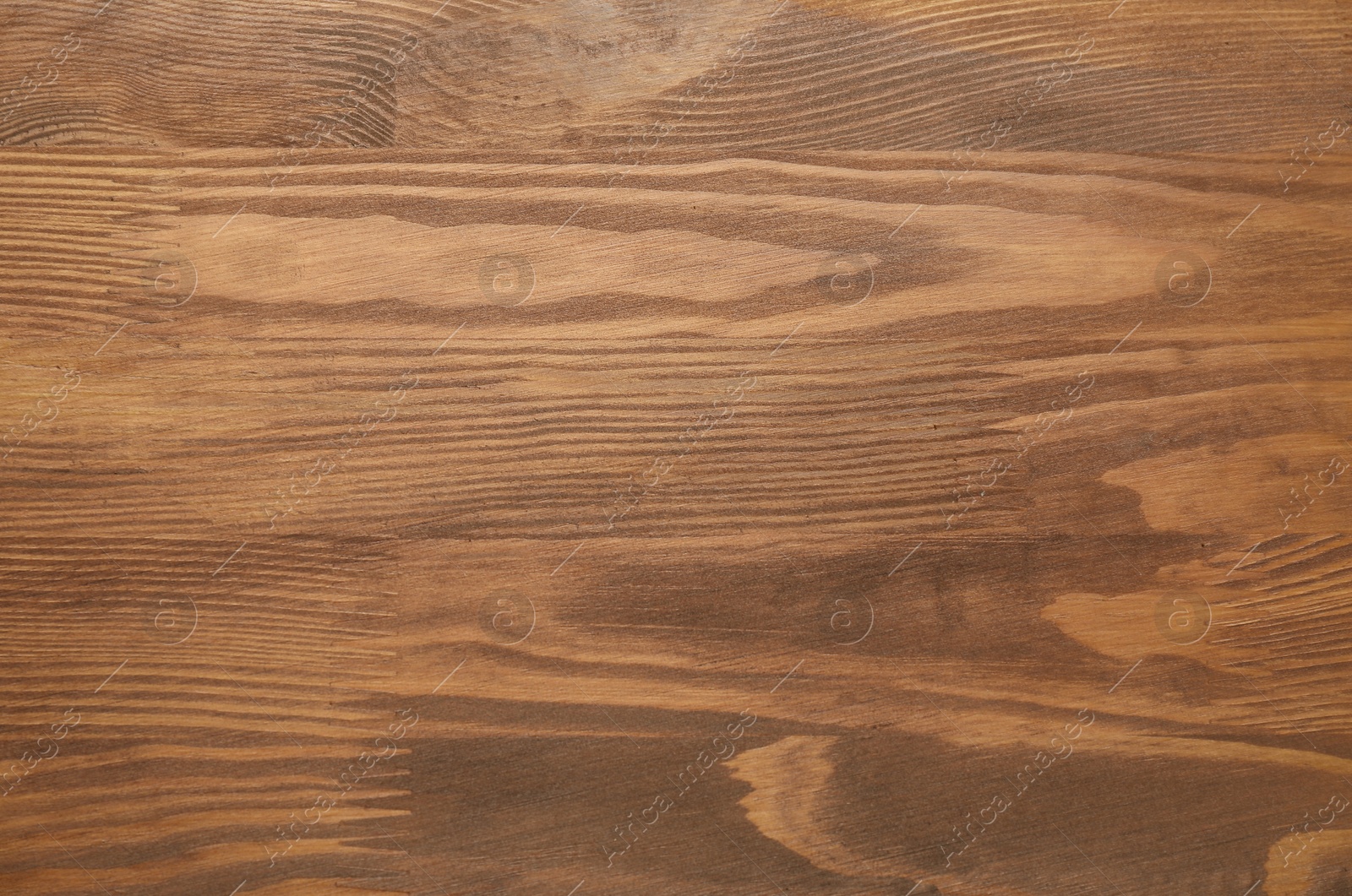 Photo of Applying walnut wood stain. Texture of wooden surface as background, top view