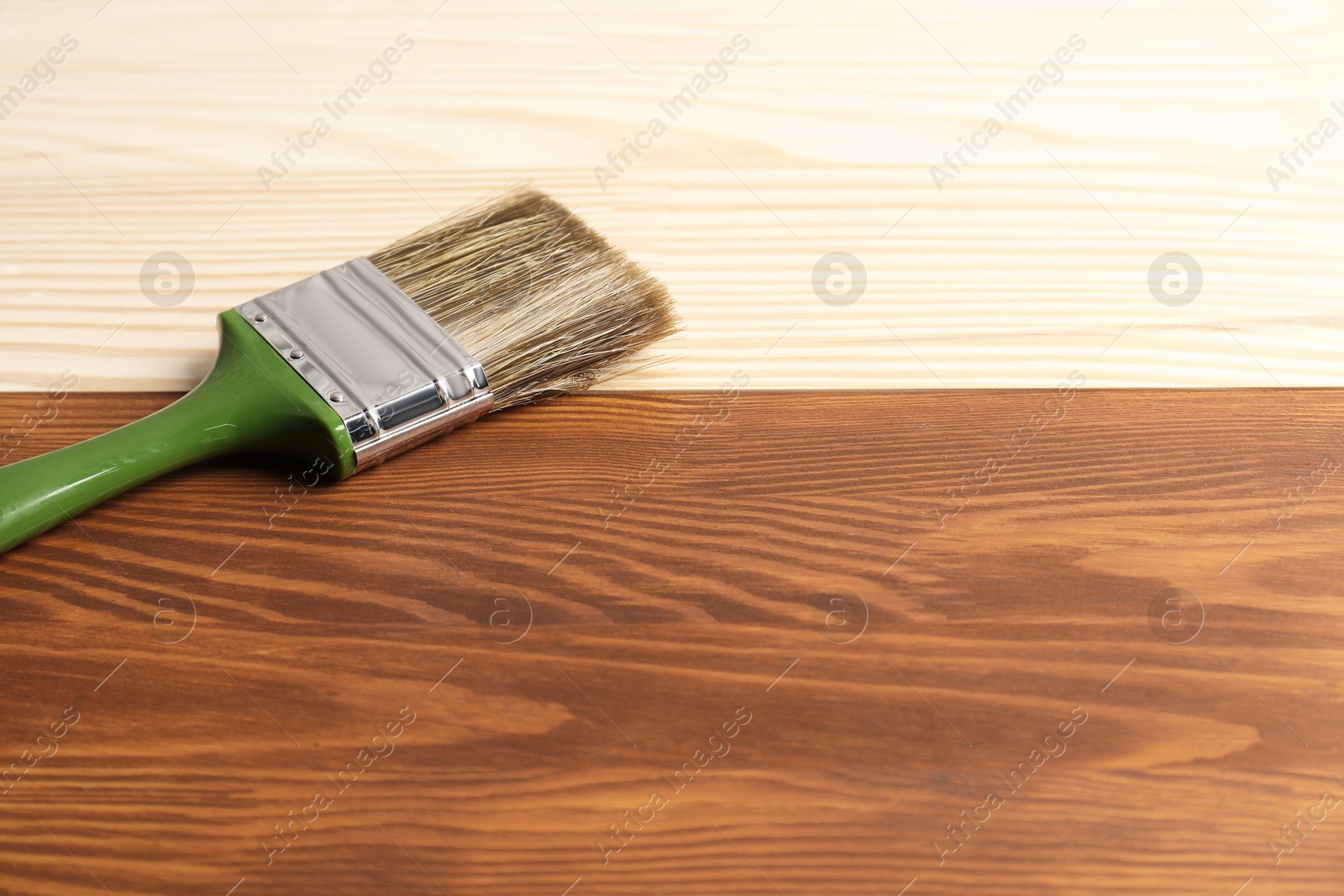 Photo of Applying walnut wood stain. Brush on wooden surface, space for text