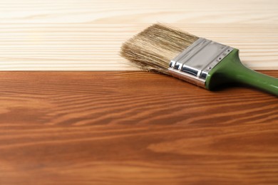 Photo of Applying walnut wood stain. Brush on wooden surface, space for text