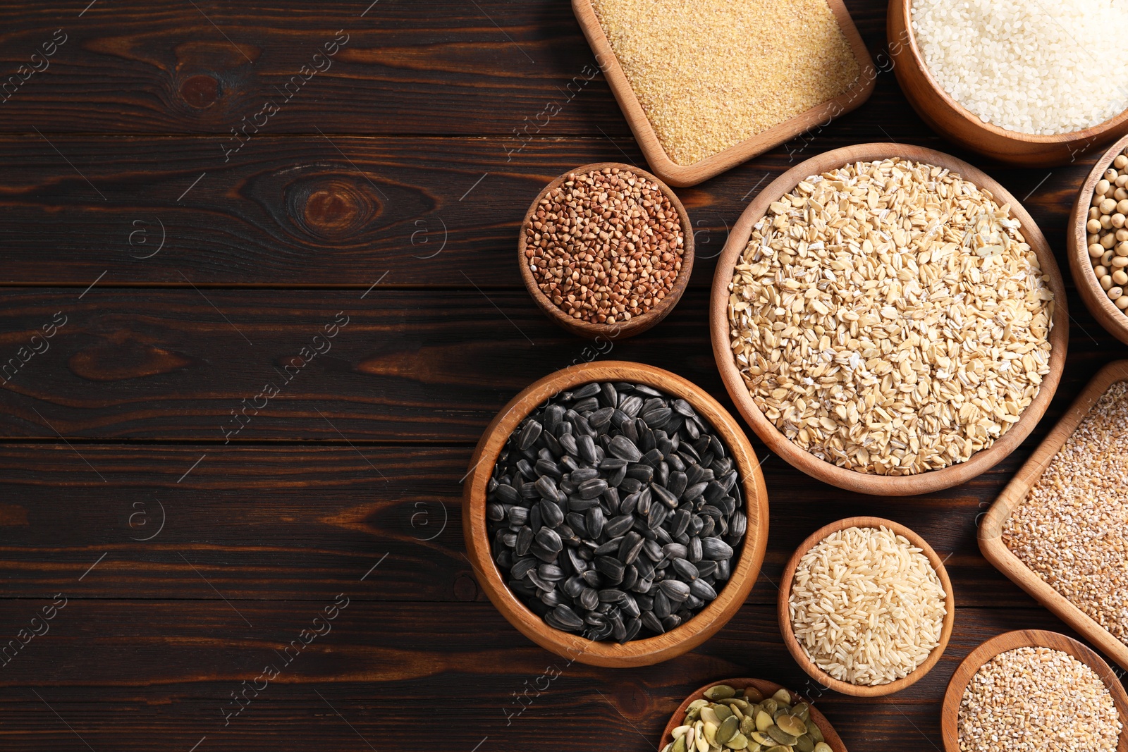 Photo of Different types of cereals, seeds and legumes on wooden table, flat lay. Space for text