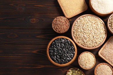 Photo of Different types of cereals, seeds and legumes on wooden table, flat lay. Space for text