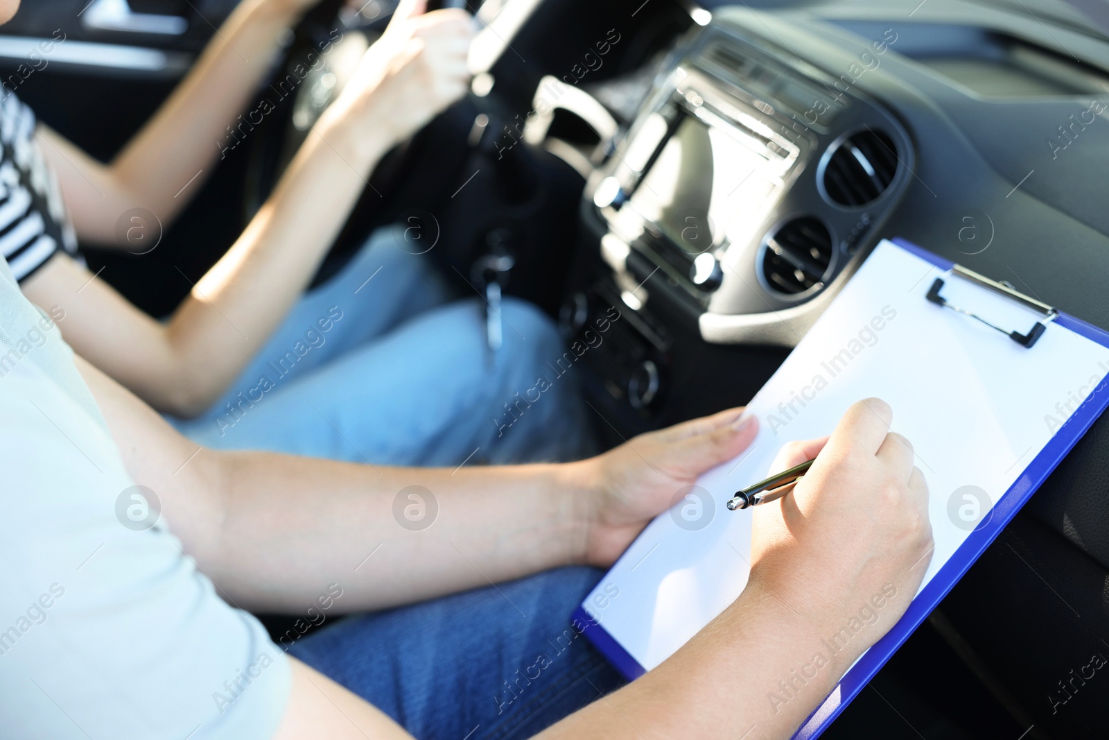 Photo of Driving school. Student passing driving test with examiner in car, closeup