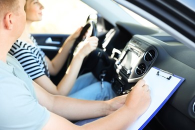 Photo of Driving school. Student passing driving test with examiner in car, closeup