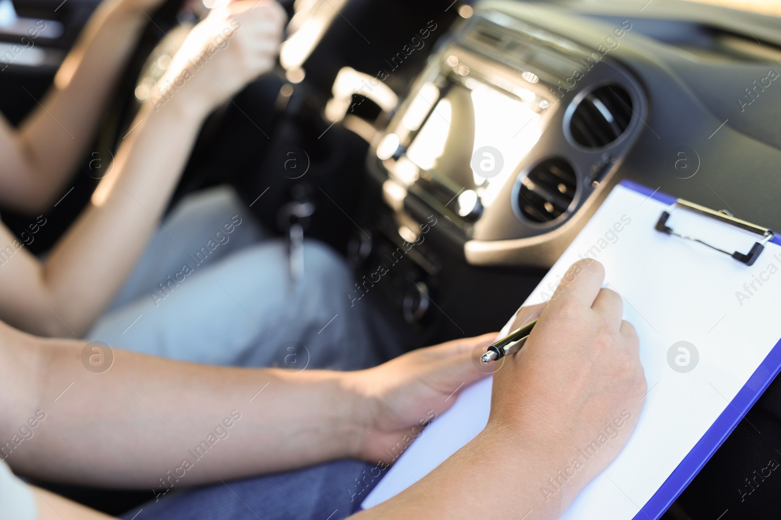 Photo of Driving school. Student passing driving test with examiner in car, closeup