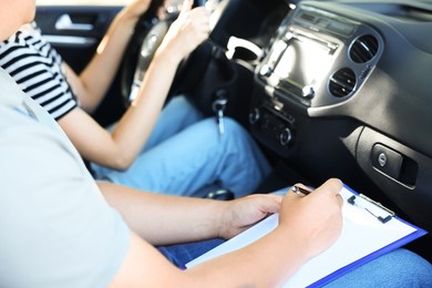 Driving school. Student passing driving test with examiner in car, closeup