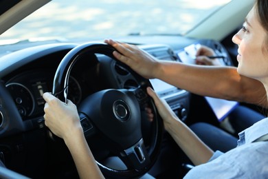 Photo of Driving school. Student passing driving test with examiner in car, closeup