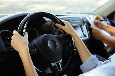 Photo of Driving school. Student passing driving test with examiner in car, closeup