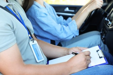 Driving school. Student passing driving test with examiner in car, closeup