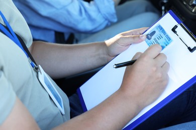 Driving school. Student passing driving test with examiner in car, closeup