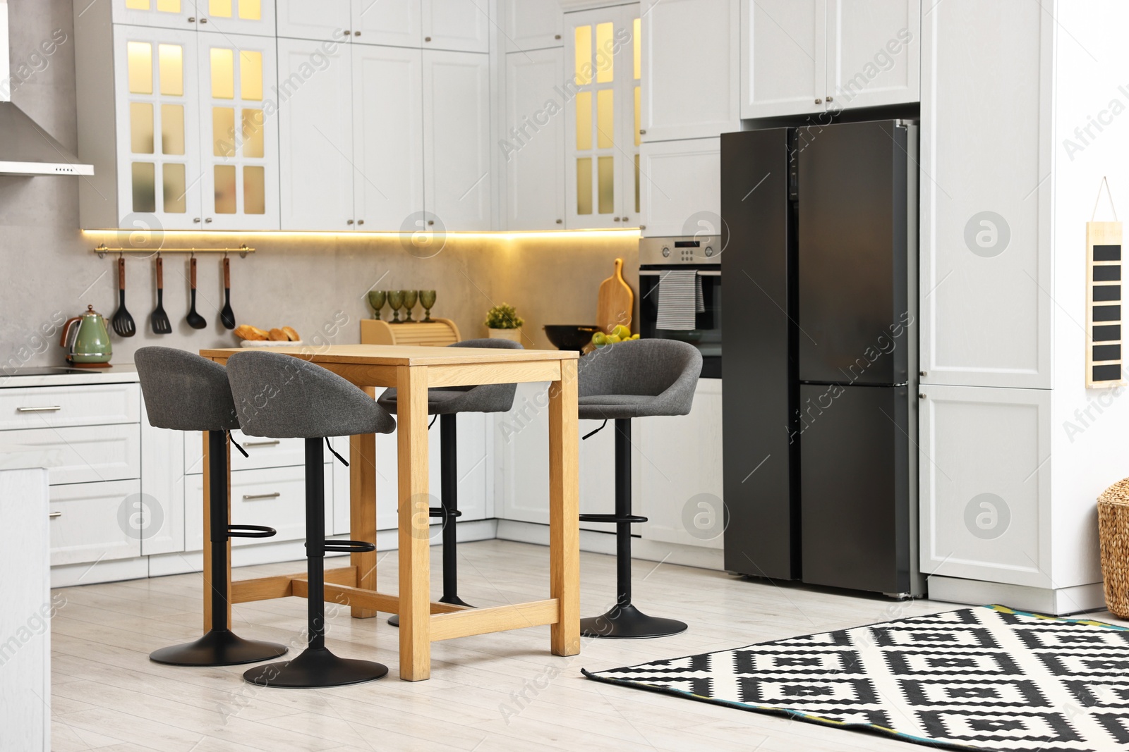 Photo of Bar stools near table in stylish kitchen