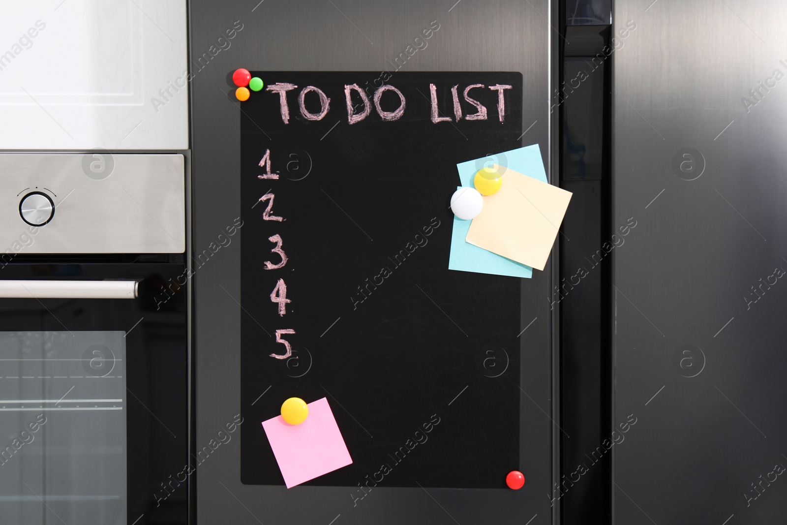 Photo of Magnetic board with to do list and notes on refrigerator in kitchen