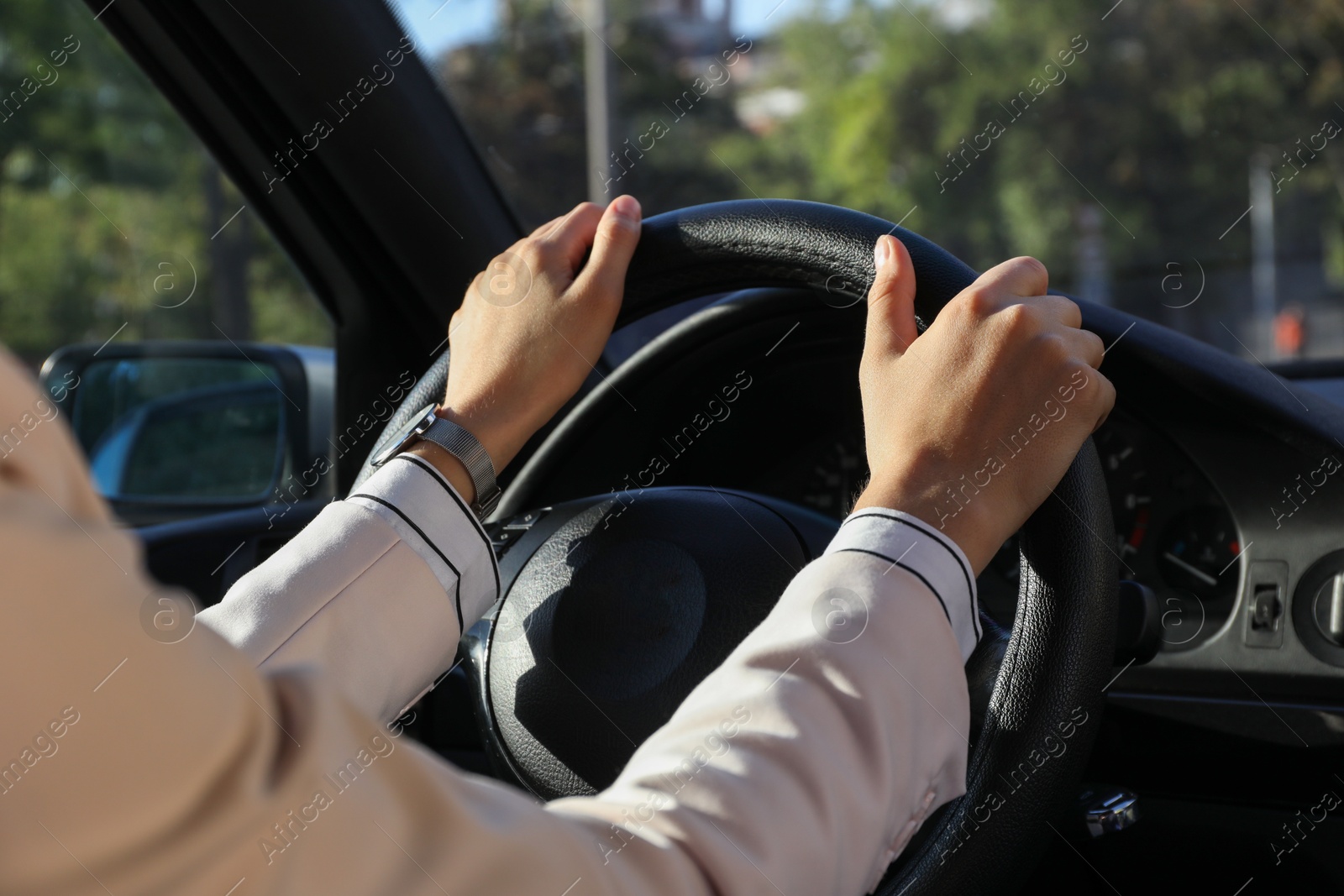 Photo of Woman holding steering wheel while driving car, closeup