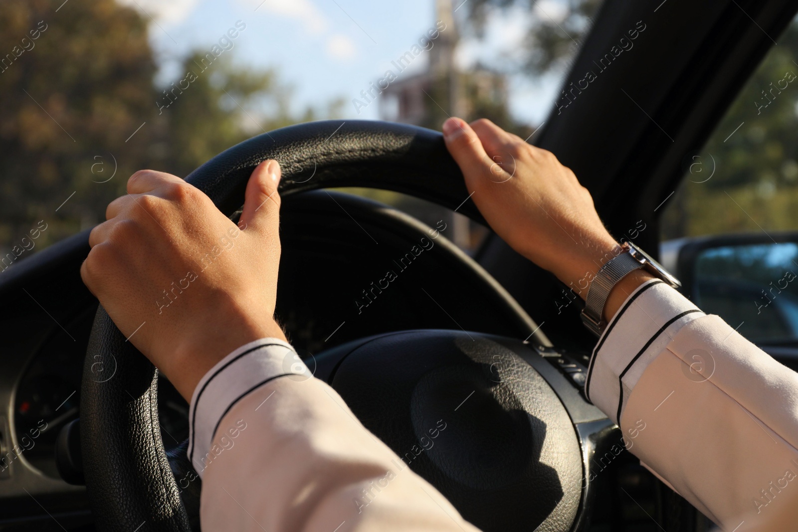 Photo of Woman holding steering wheel while driving car, closeup