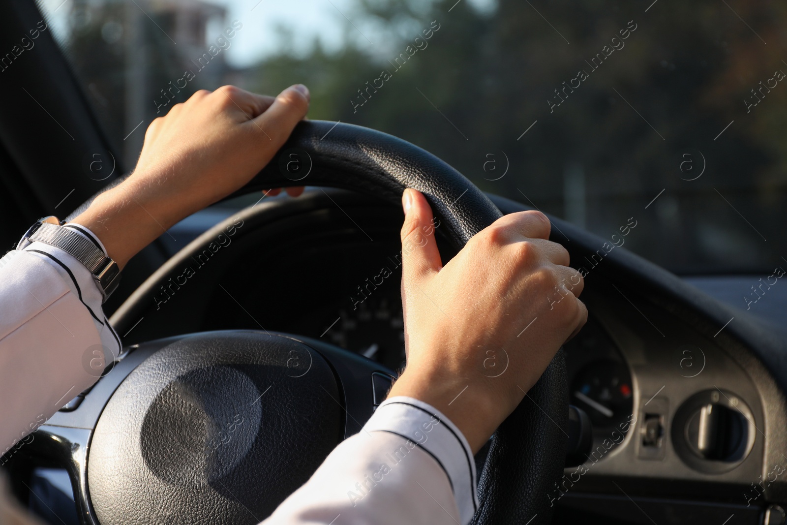 Photo of Woman holding steering wheel while driving car, closeup