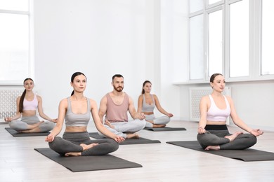 Group of people meditating on mats in yoga class