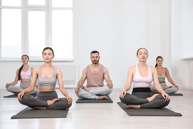 Group of people meditating on mats in yoga class