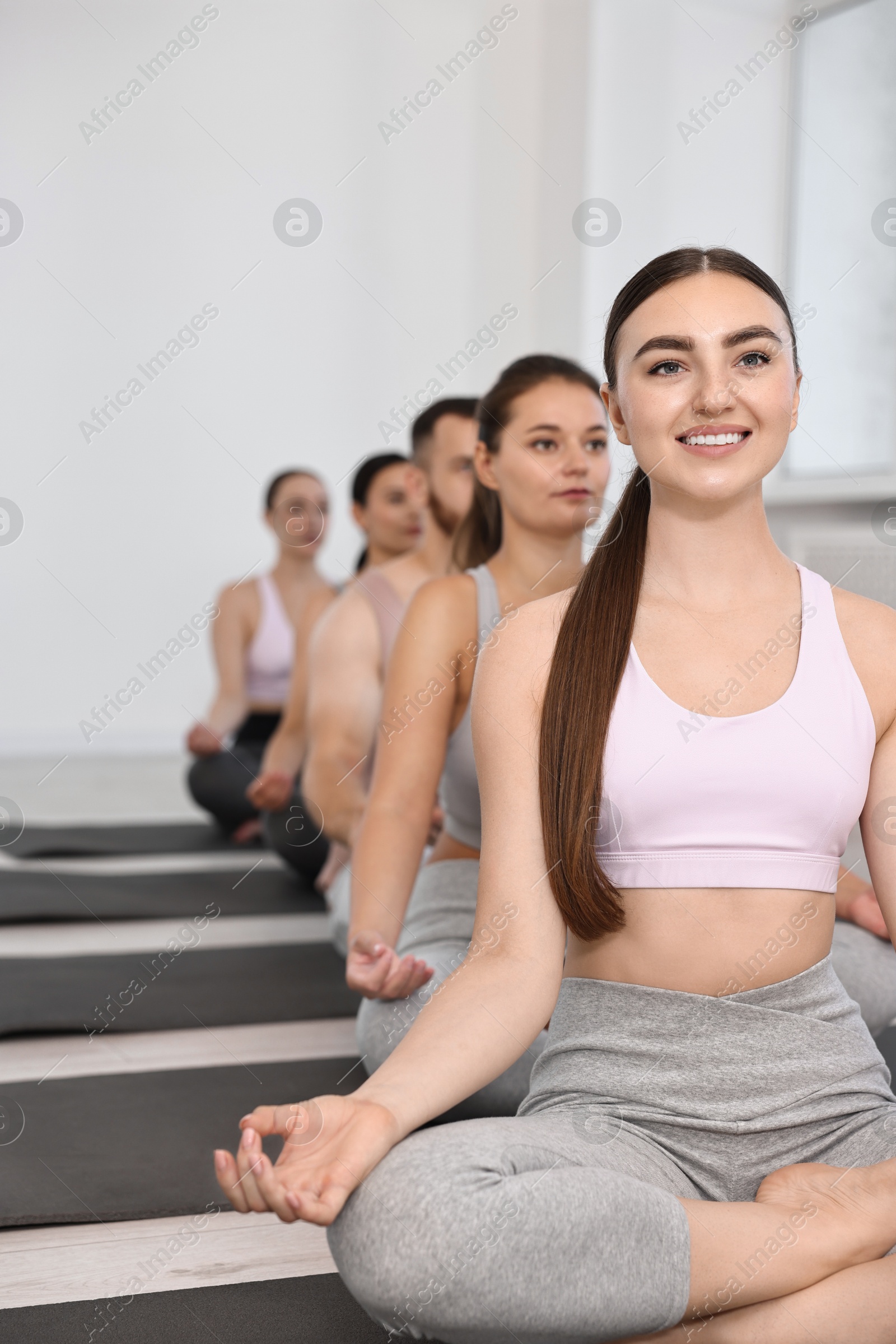 Photo of Group of people meditating on mats in yoga class