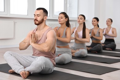 Group of people meditating on mats in yoga class