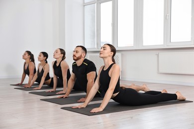 Group of people practicing yoga on mats in class