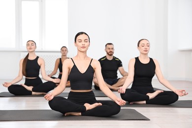 Group of people meditating on mats in yoga class