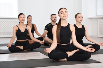 Group of people meditating on mats in yoga class