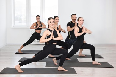 Group of people practicing yoga on mats in class