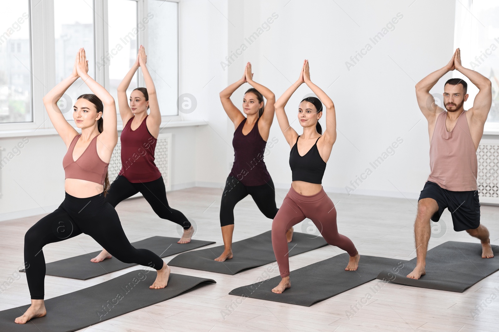 Photo of Group of people practicing yoga on mats in class