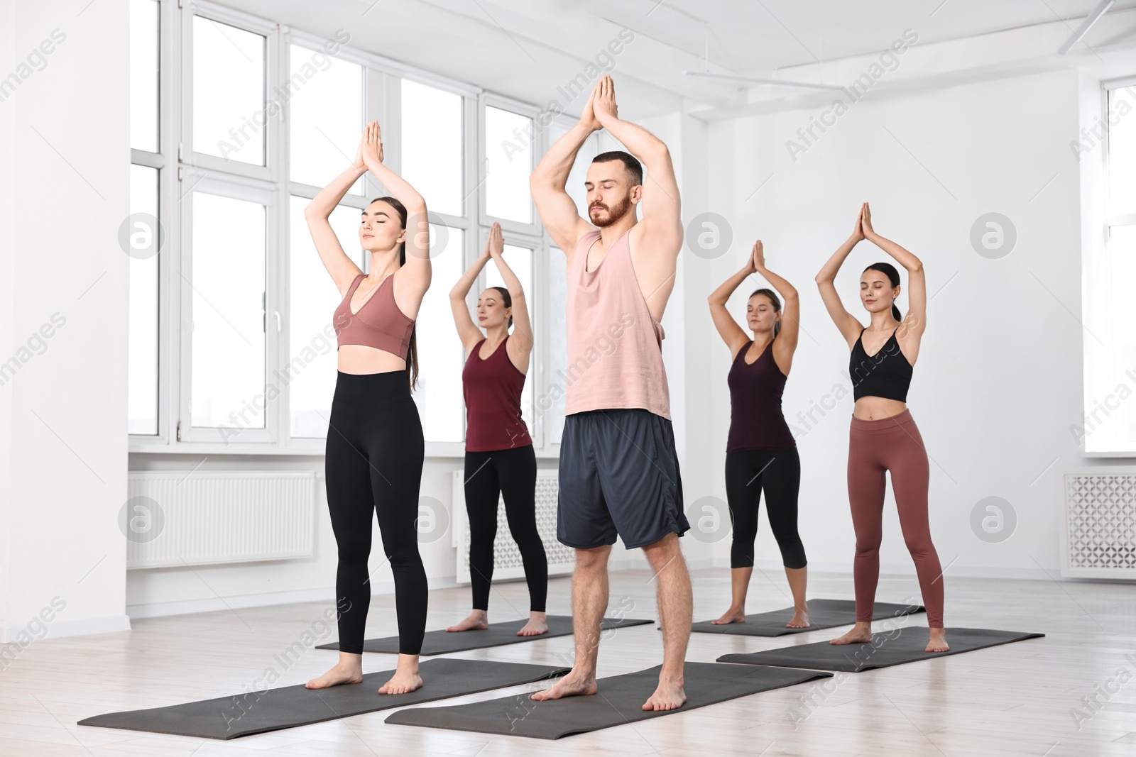 Photo of Group of people meditating on mats in yoga class