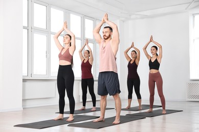 Group of people meditating on mats in yoga class