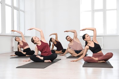 Photo of Group of people practicing yoga on mats in class