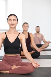 Photo of Group of people meditating on mats in yoga class