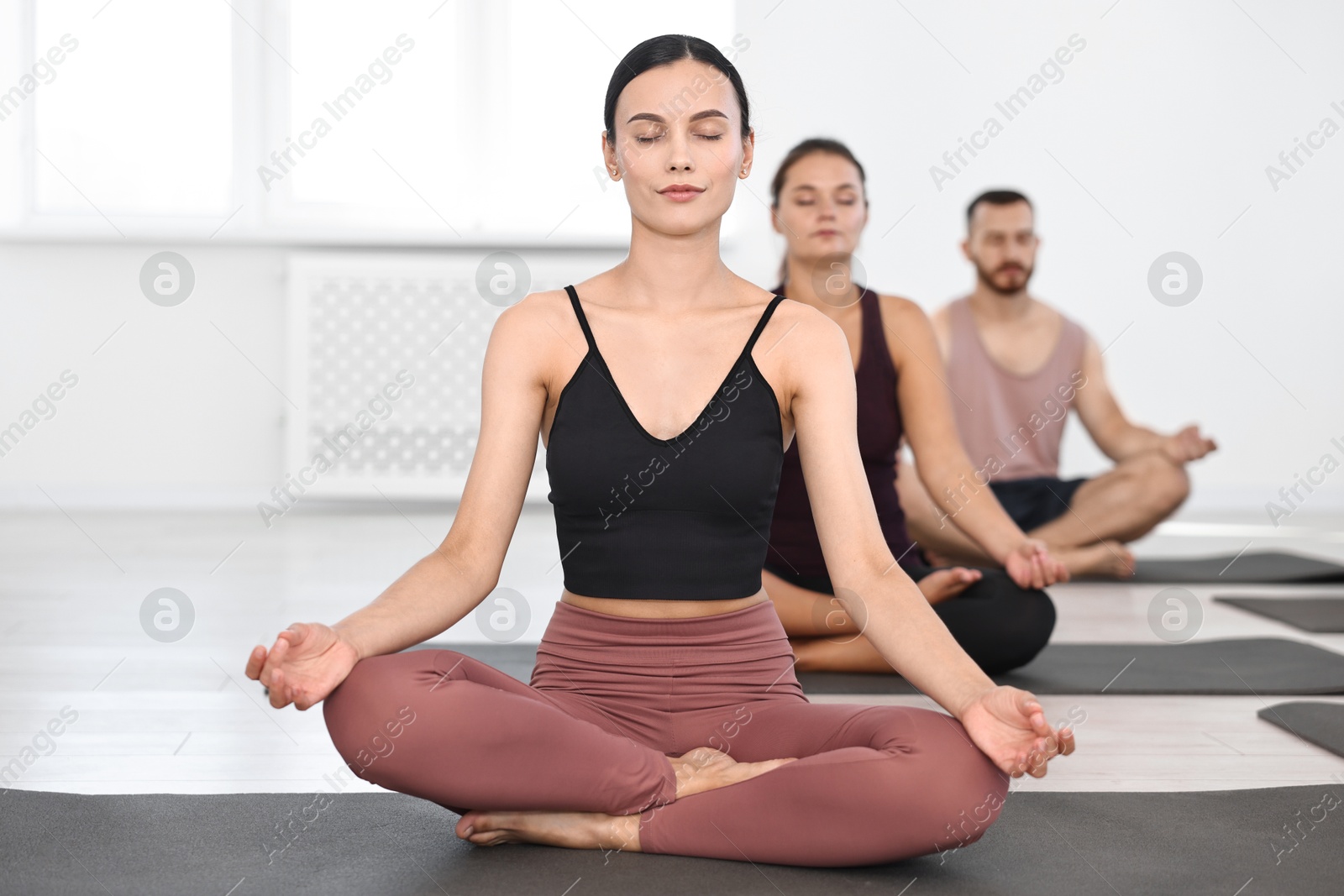 Photo of Group of people meditating on mats in yoga class