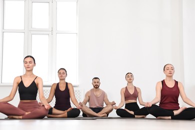 Group of people meditating on mats in yoga class