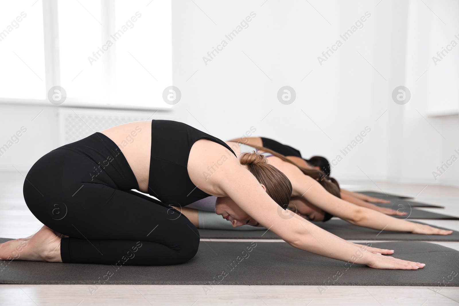 Photo of Group of people practicing yoga on mats in class