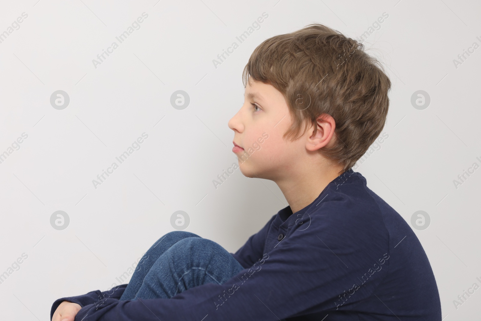 Photo of Autism concept. Lonely little boy near light wall at home