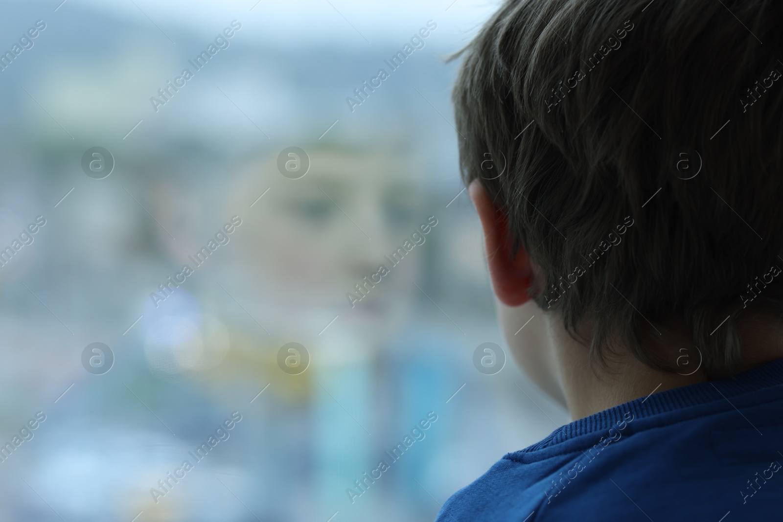 Photo of Autism concept. Lonely little boy near window at home, space for text