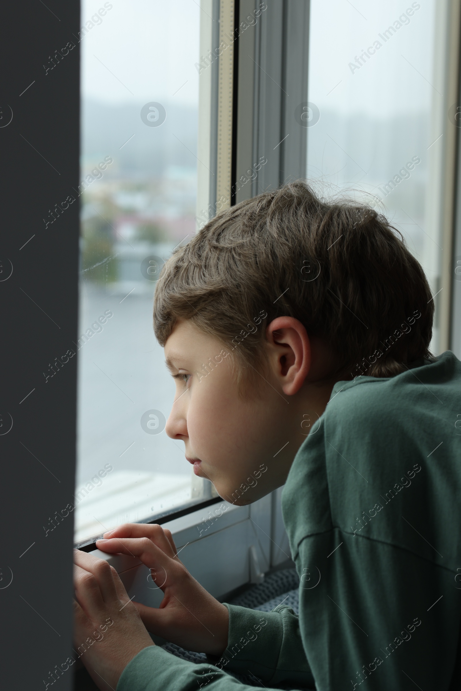 Photo of Autism concept. Lonely little boy near window at home