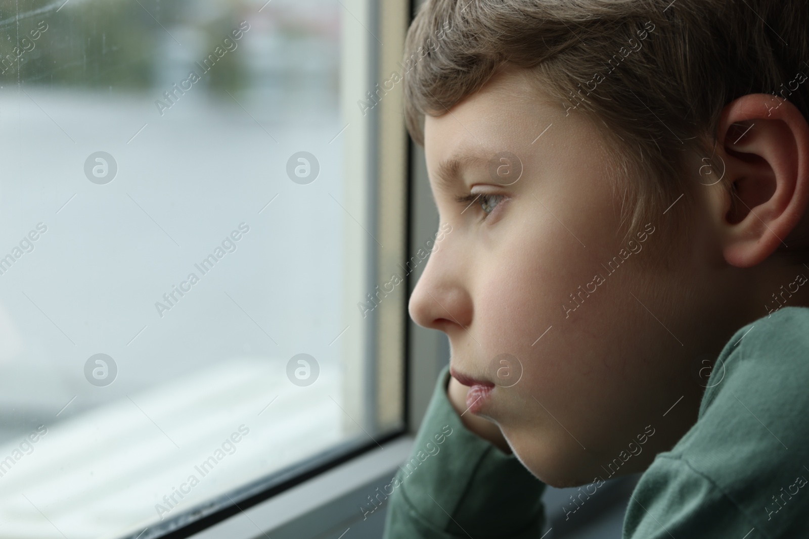 Photo of Autism concept. Lonely little boy near window at home, space for text